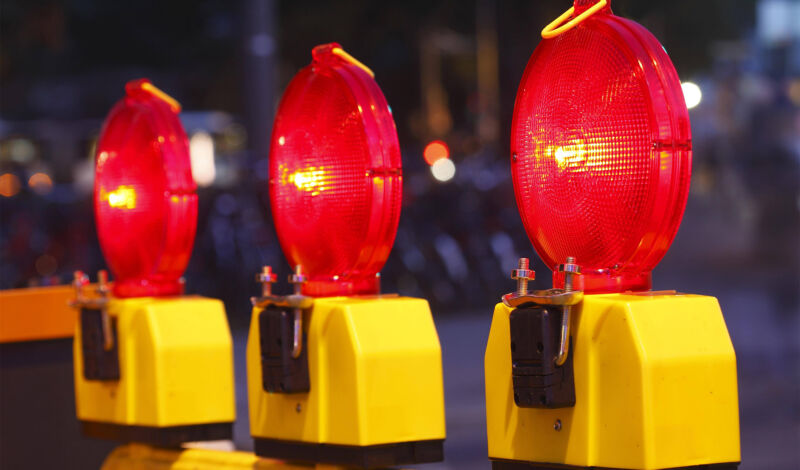 Warnleuchten weisen auf eine Straßensperrung hin.