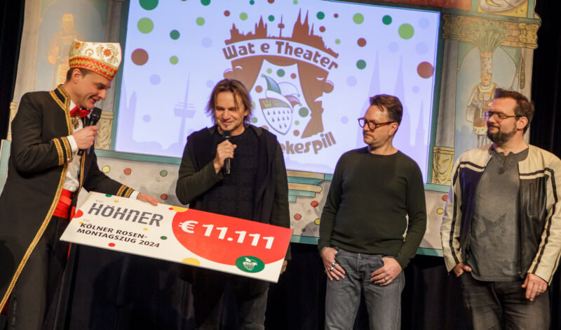 Mehrere Mitglieder der Band Höhner überreichen Zugleiter Holger Kirsch einen Spendenscheck