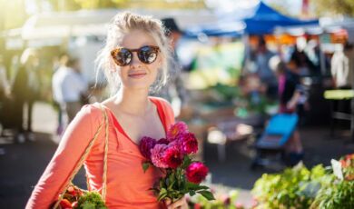 Frau mit Blumenstrauß auf einem Markt