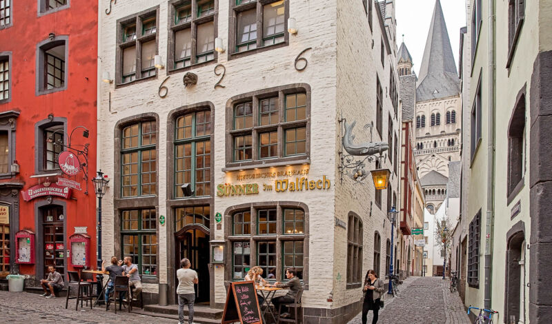 Das Brauhaus Sünner im Walfisch in der Kölner Altstadt mit der Kirche Groß St. Martin im Hintergrund