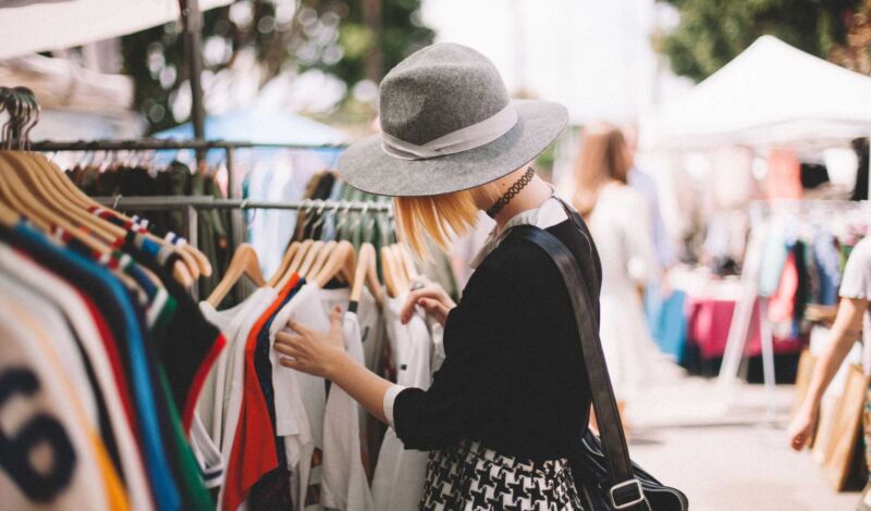 Junge Frau schlendert über einen Flohmarkt
