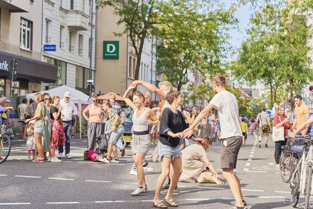 Menschen tanzen beim Tag des guten Lebens auf der Straße