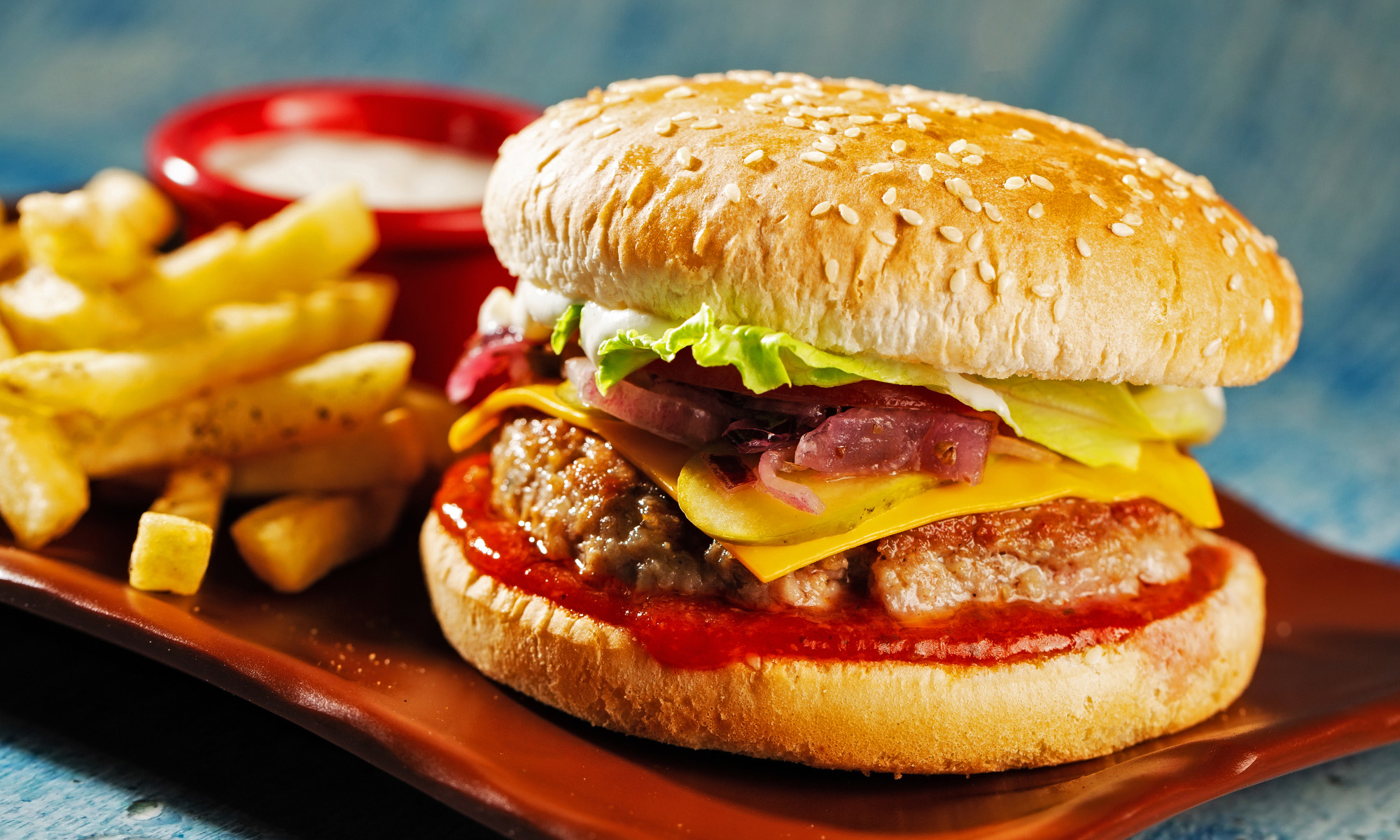 Ein Cheeseburger mit Sesambun und Pommes Frites