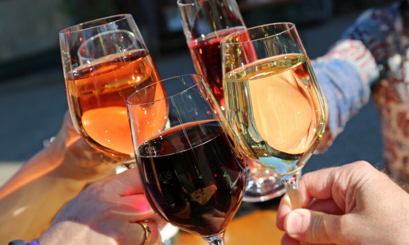 Feierabendmarkt auf dem Neptunplatz 1 Menschen stoßen mit Weingläsern an