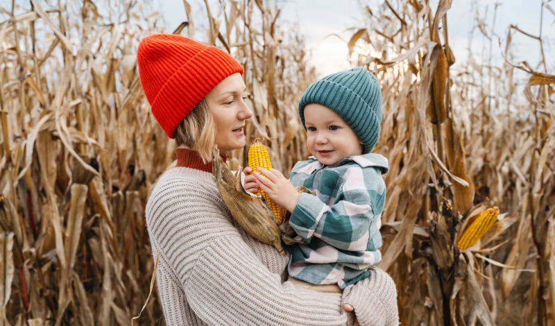 Frau mit Kind vor Maislabyrinth
