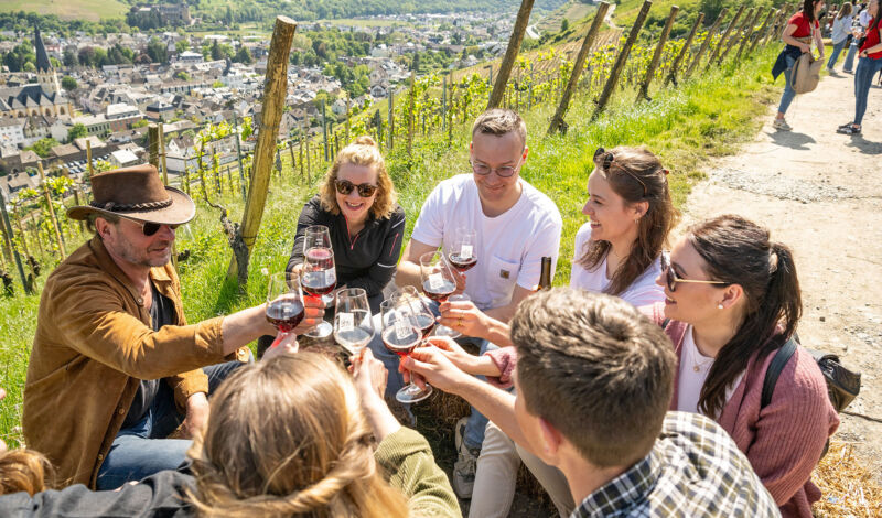 Wandergruppe stößt im Weinberg des Ahrtales mit Weißwein an.
