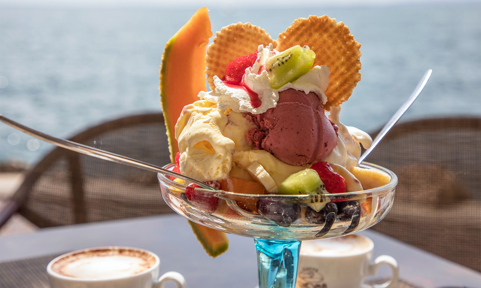 Ein Eisbecher mit verschiedenen Eissorten sowie Früchten und Waffeln.