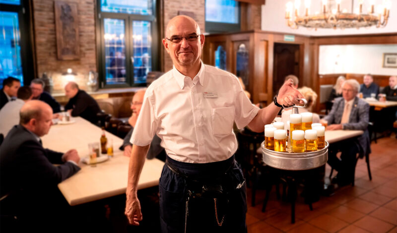 Ein Köbes im Brauhaus Jan von Werth hält einen Kranz mit Kölsch.