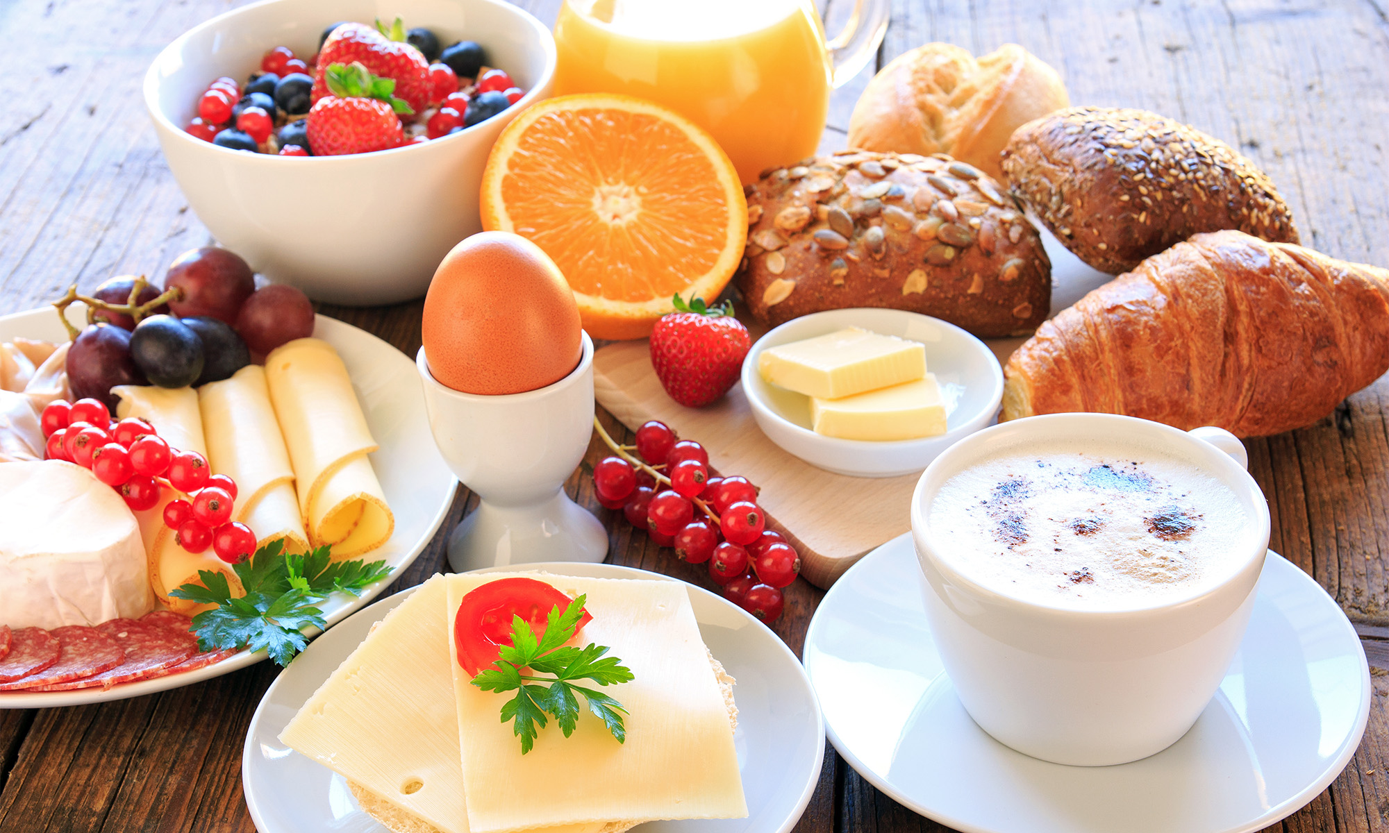 Ein mit verschiedenen Speisen und Getränken gedeckter Frühstückstisch.