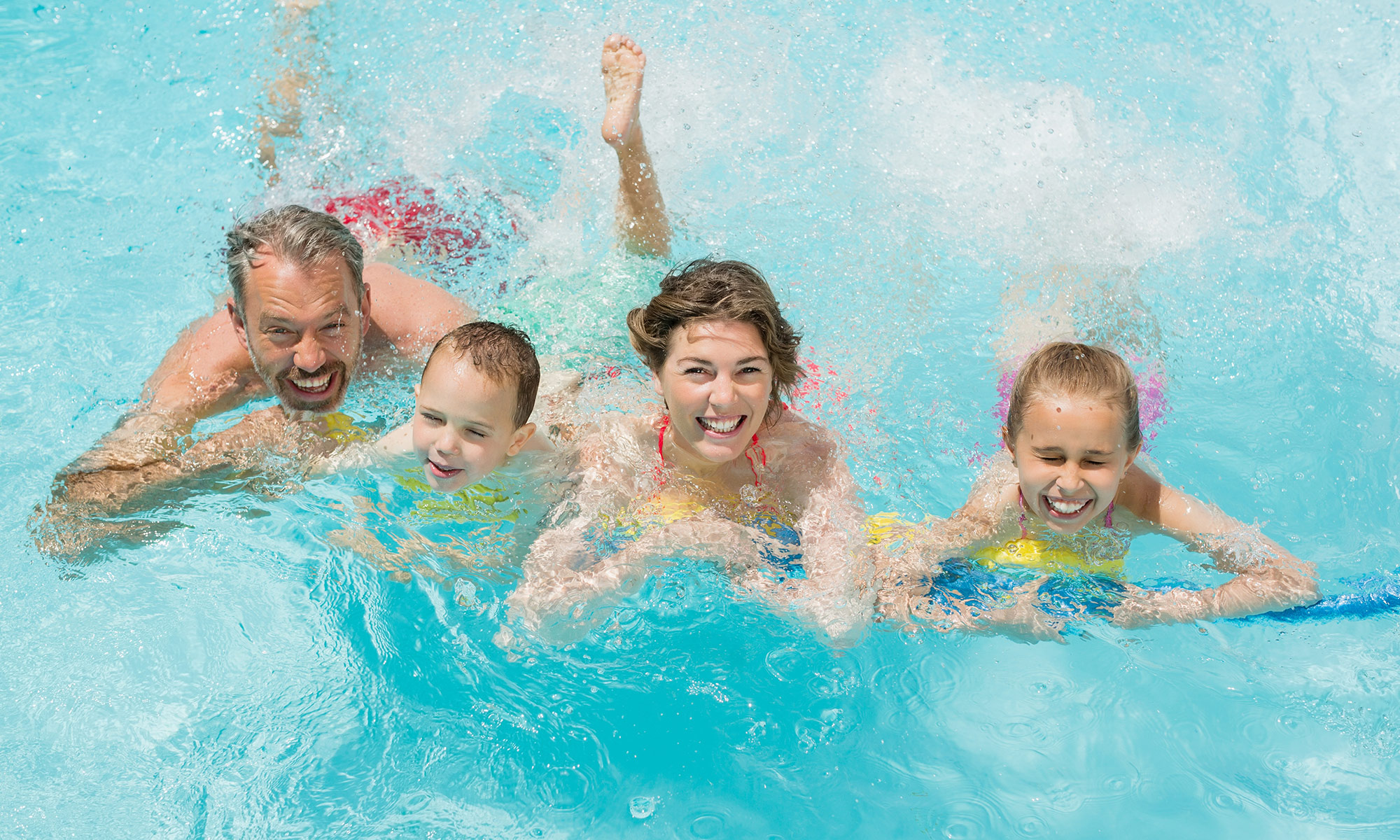 Eine Schwimmerin in gelbem Badeanzug zieht unter Wasser ihre Bahn.