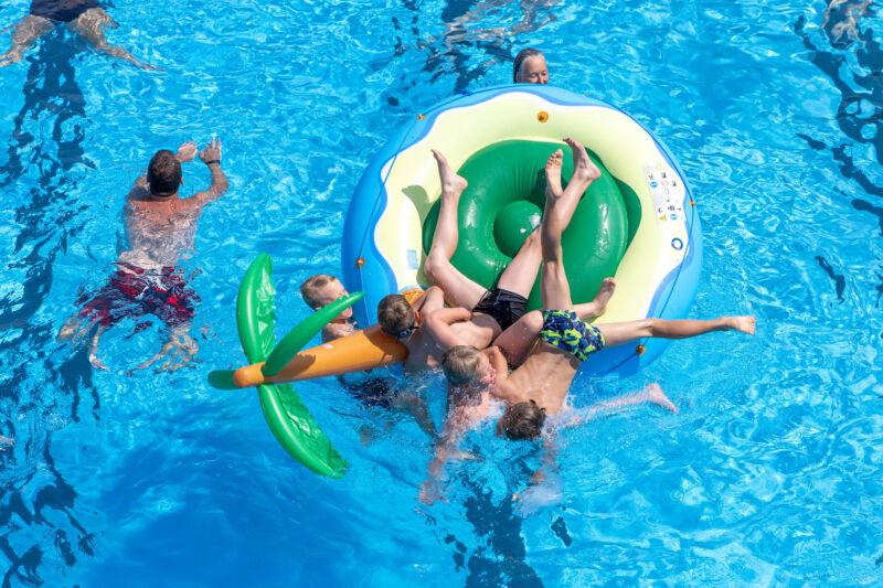Eine Schwimmerin in gelbem Badeanzug zieht unter Wasser ihre Bahn.
