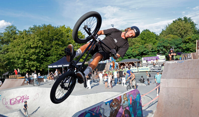Ein BMX-Fahrer springt mit seinem Rad über eine Rampe