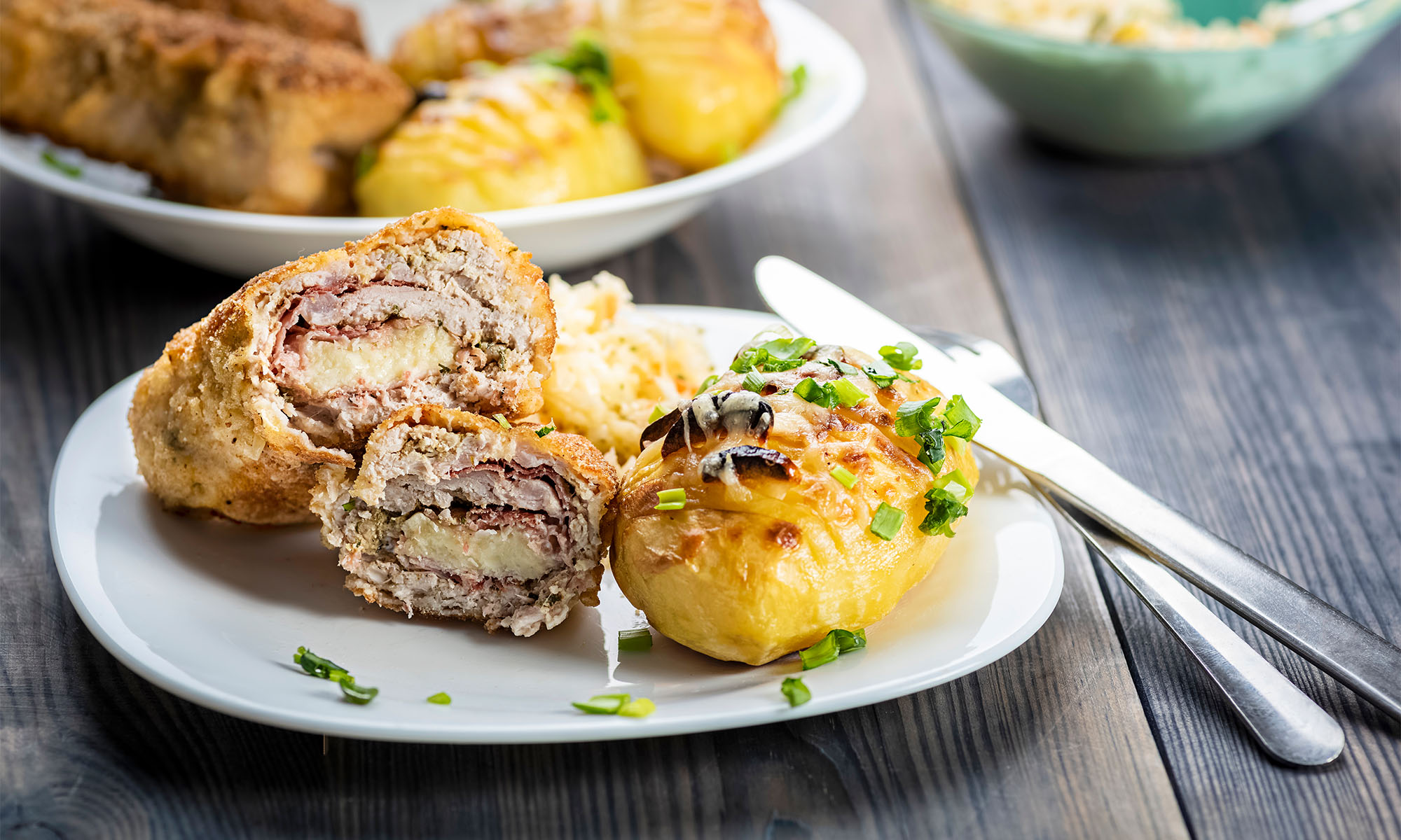 Ein Teller mit Stücken vom Cordon bleu sowie gegrillte Kartoffeln