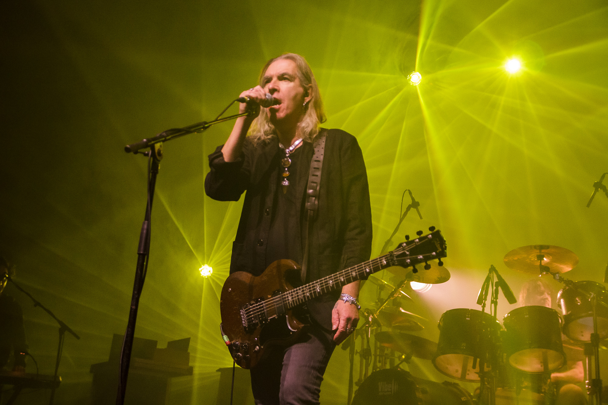 Sänger Justin Sullivan von New Model Army steht mit einer Gitarre am Mikrofon