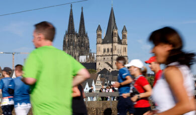 Läufer beim Köln Marathon von hinten, im Hintergrund der Kölner Dom