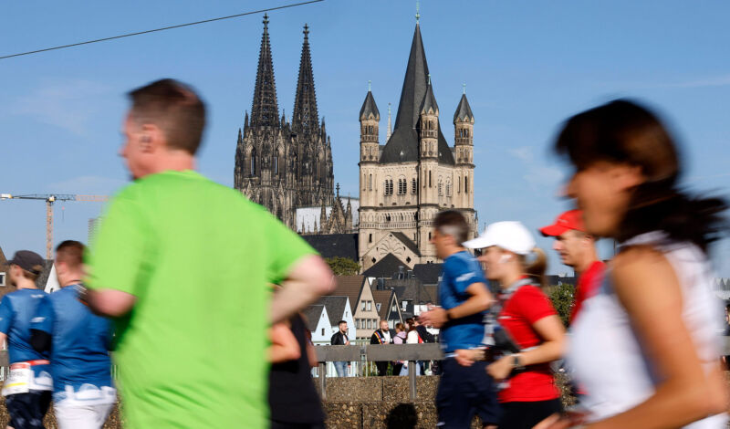 Läufer beim Köln Marathon von hinten, im Hintergrund der Kölner Dom