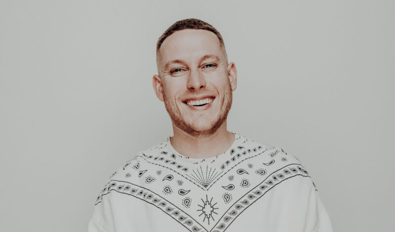 Der Kölner Sänger und Rapper Mo-Torres in einem weißen Pullover.