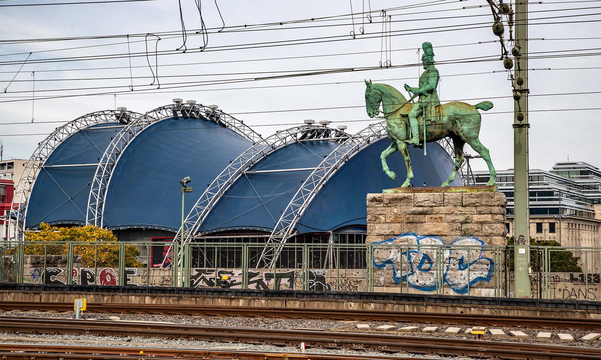Blick auf den Musical Dome in Köln, im Vordegrund sind Eisenbahngleise zu sehen.