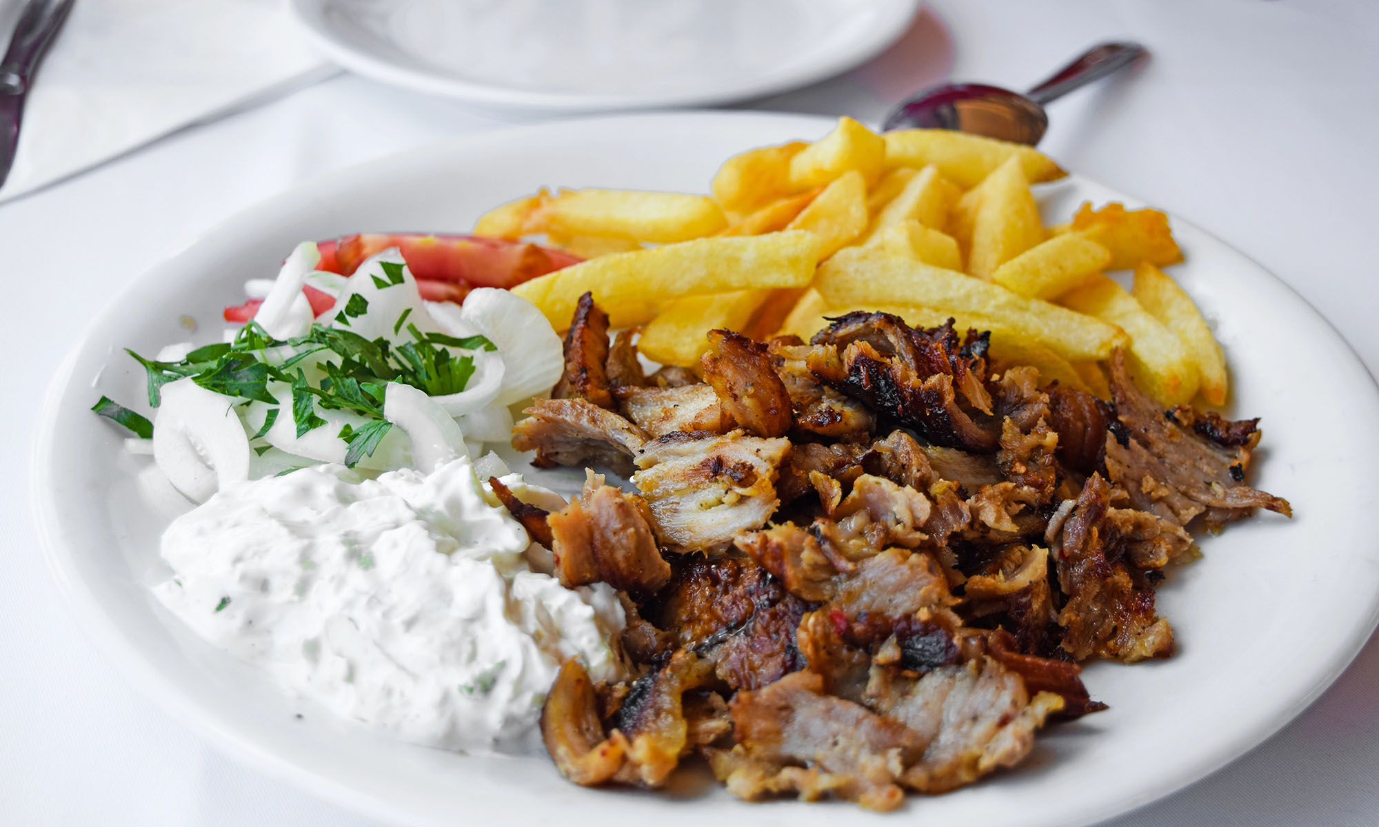 Ein Teller mit Gyros, Pommes Frites und Tzatziki
