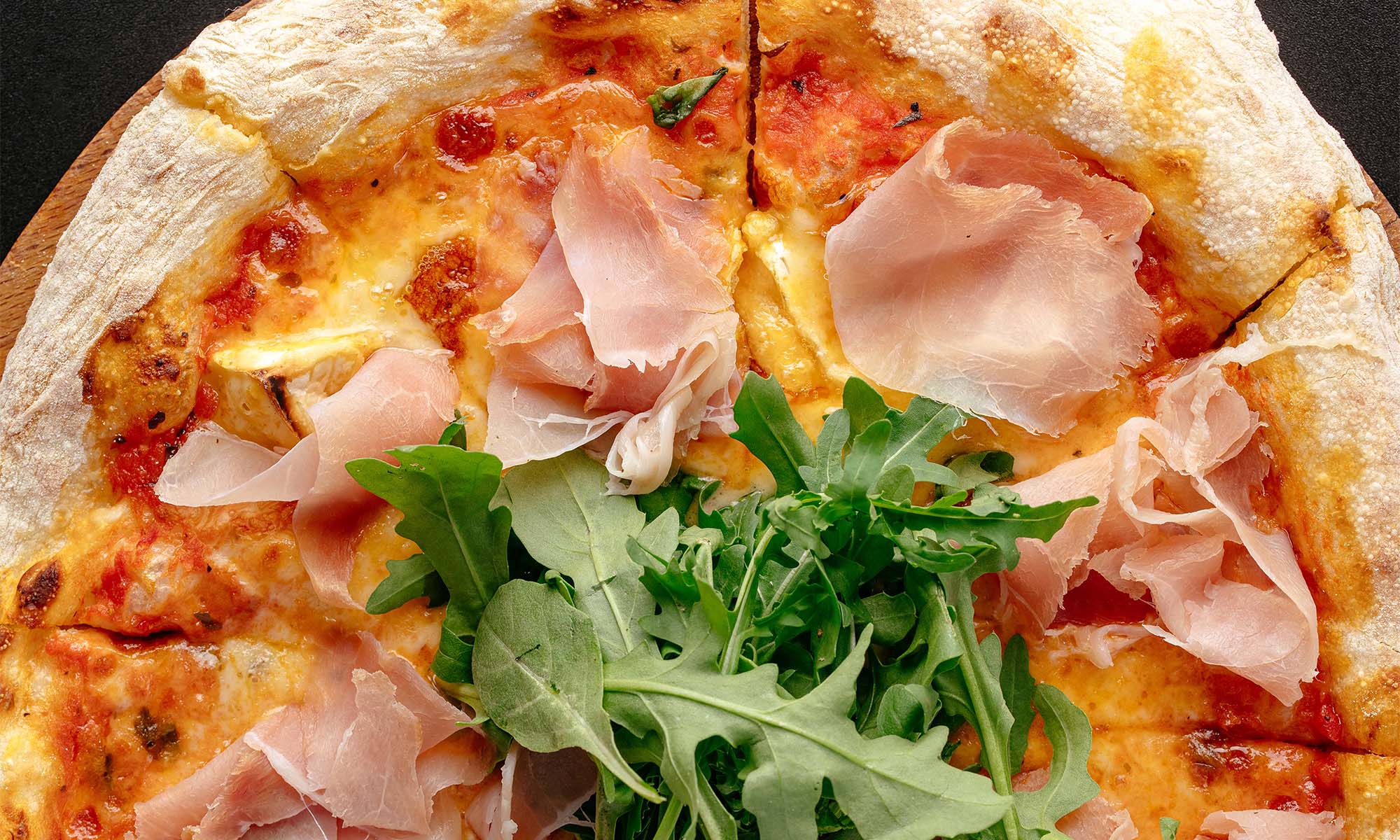 Pizza Eine Pizza mit Schinken und Rucola (Rauke)