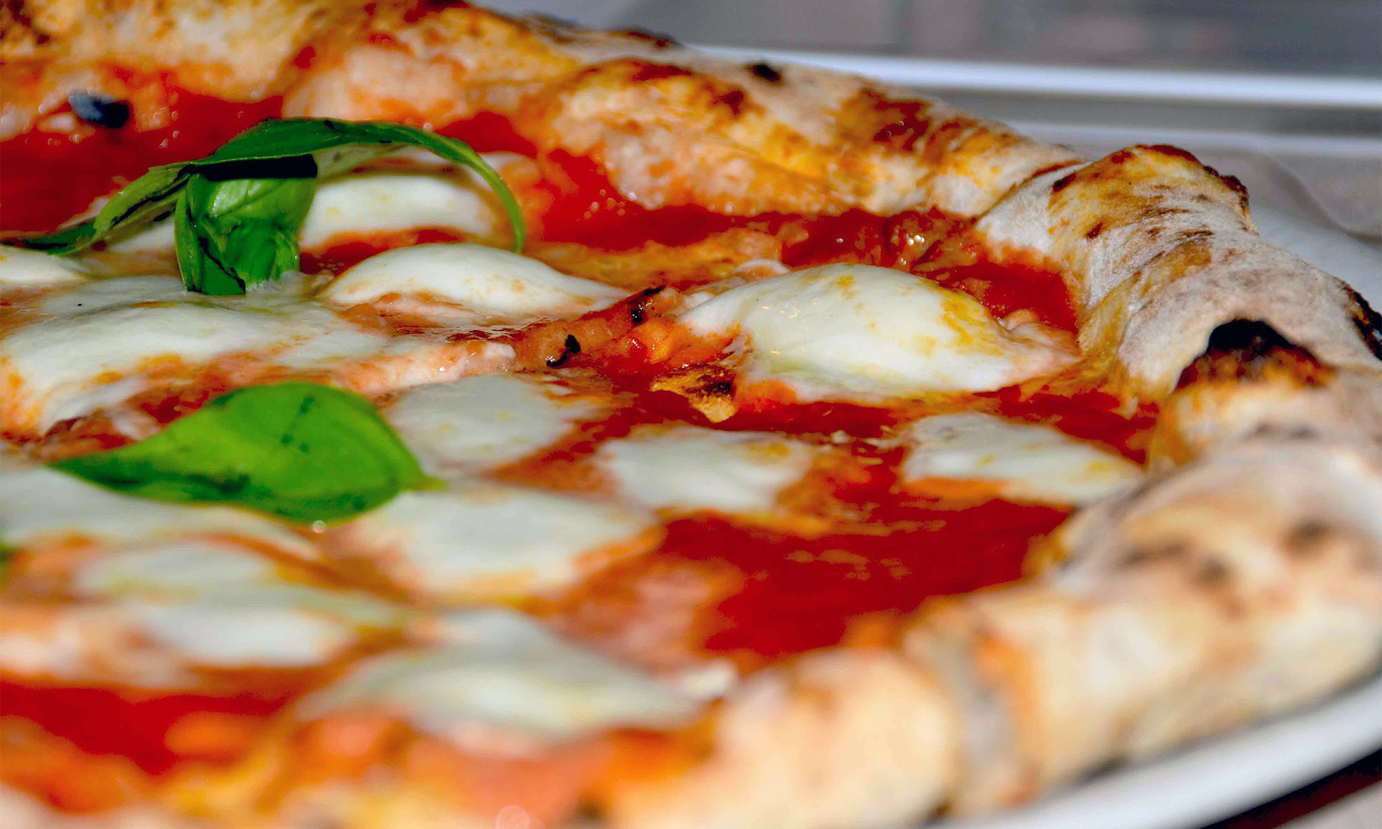 Eine Pizza Margherita mit Tomate, Mozzarella und Basilikum