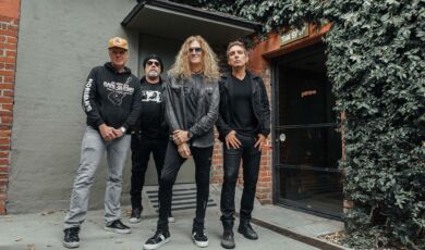 Die vier Musiker der Rock-Supergroup Black Country Communion stehen an einem Gebäudeeingang