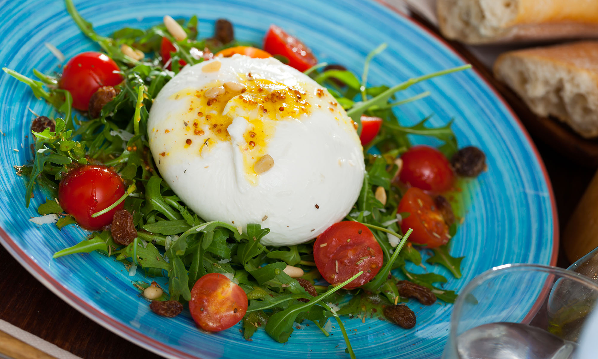 Burrata auf einem Bett von Rucola mit Kirschtomaten