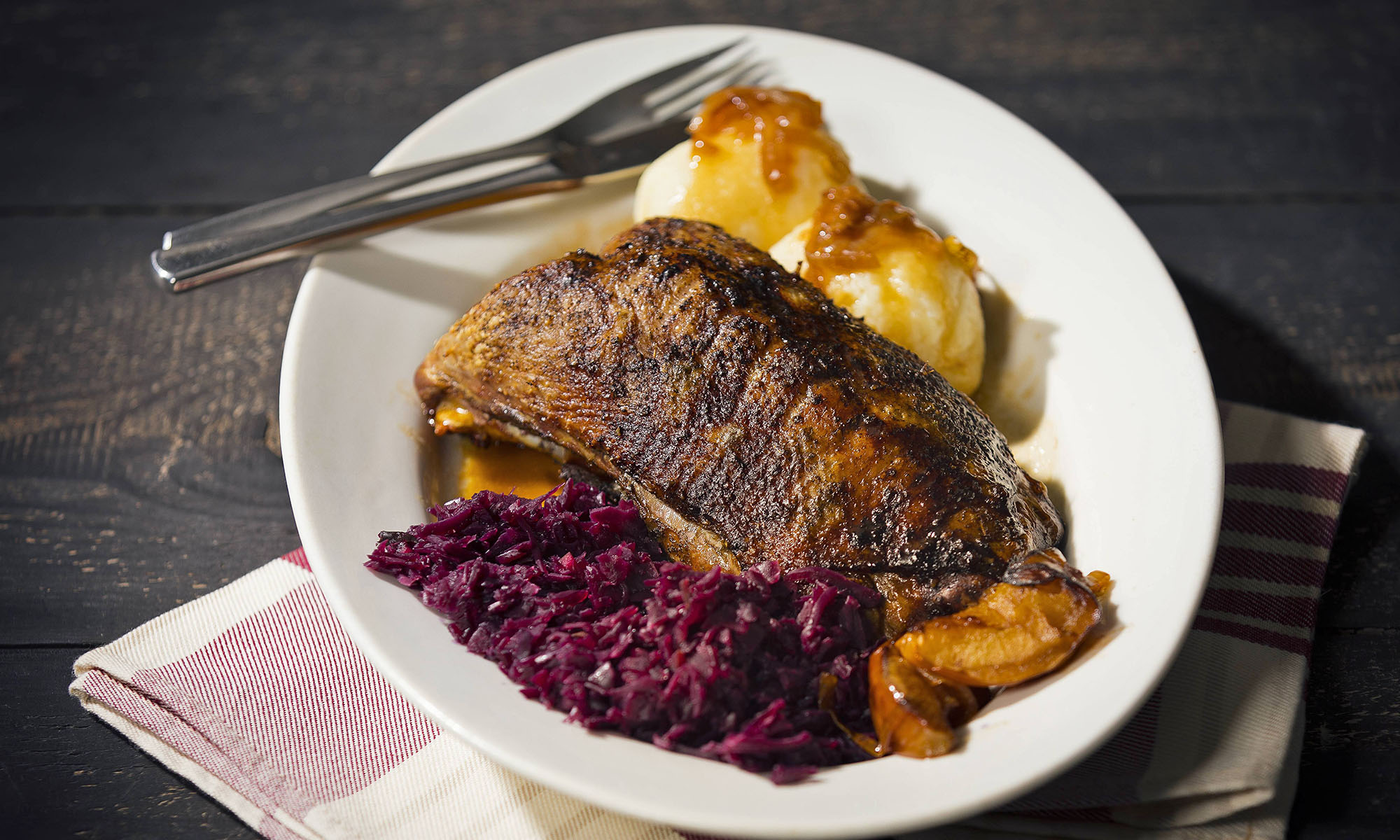 Gebratene Ente mit Rotkohl und Klößen mit Soße.