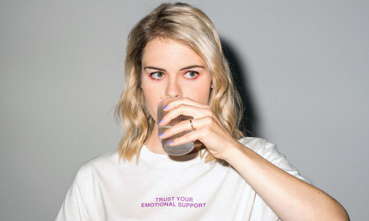 Die Comedienne Hazel Brugger trinkt ein Getränk aus einem Glas.