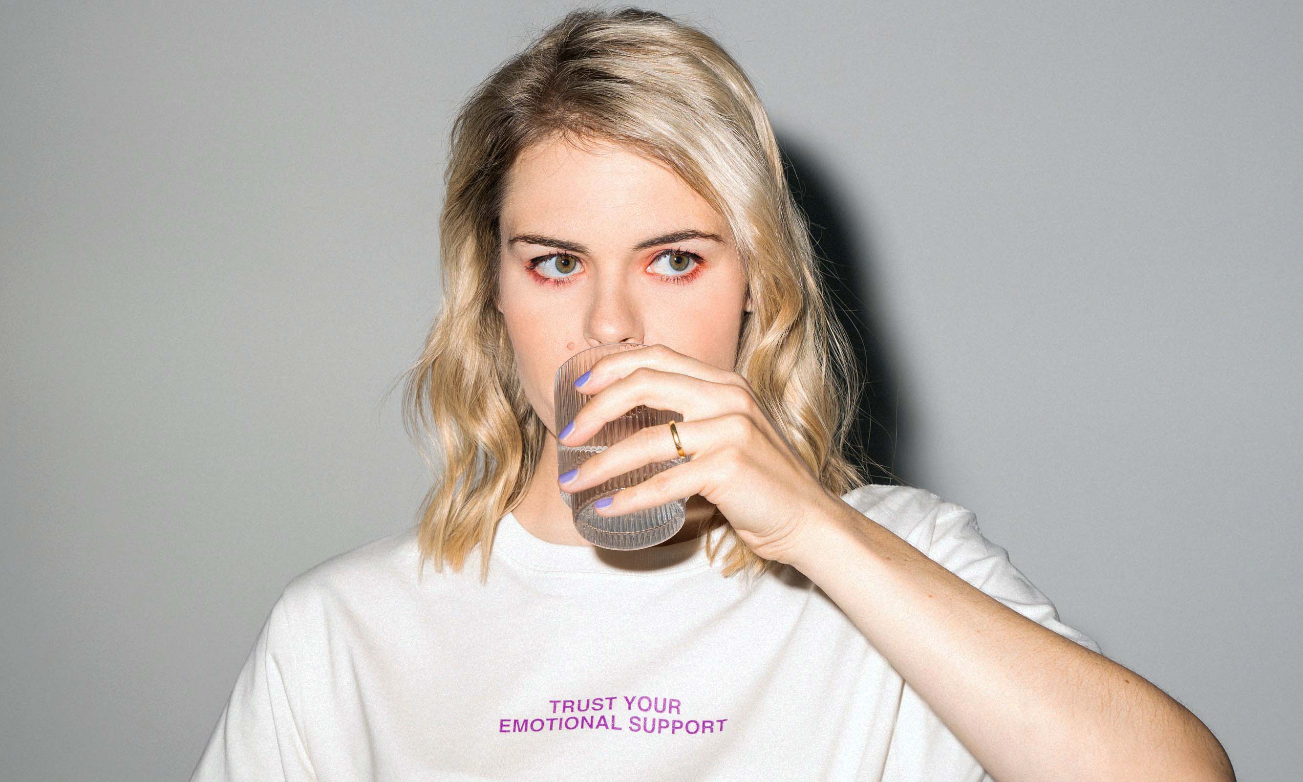 Die Comedienne Hazel Brugger trinkt ein Getränk aus einem Glas.