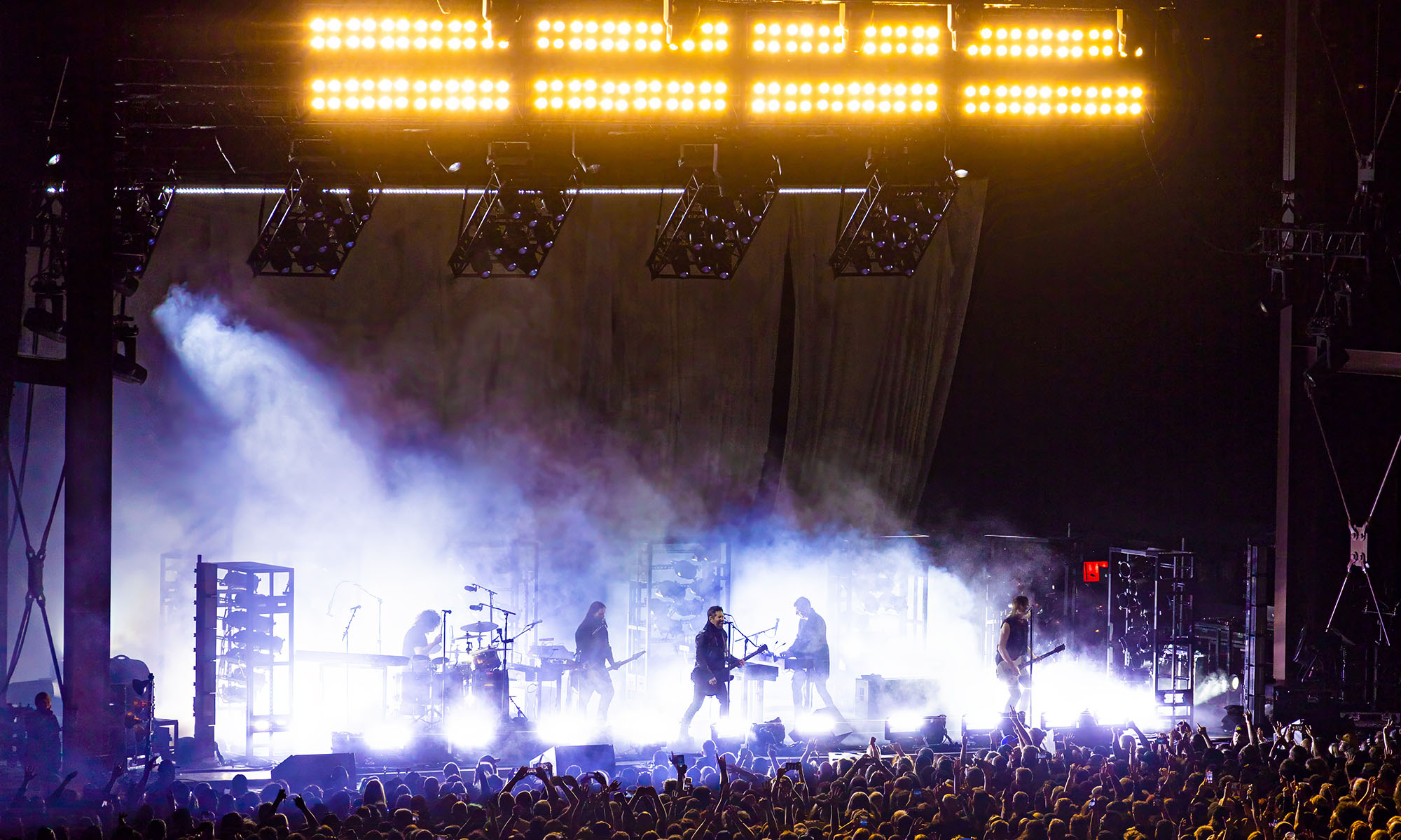 Die Rockband Nine Inch Nails steht inmitten von Kunstnebel auf einer