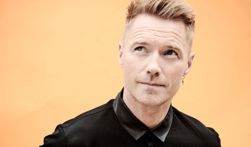 Der Sänger Ronan Keating in Großaufnahme vor einem beigen Hintergrund