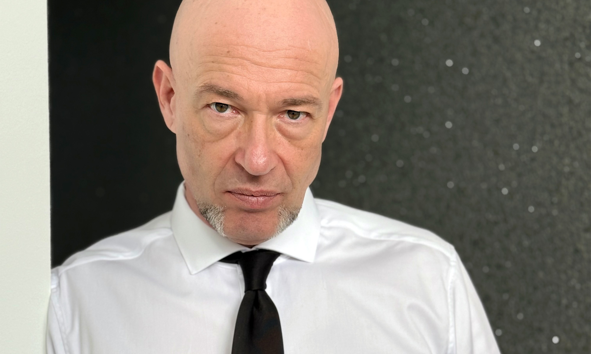 Der Graf von Unheilig in weißem Hemd und mit schwarzer Krawatte im Porträt.