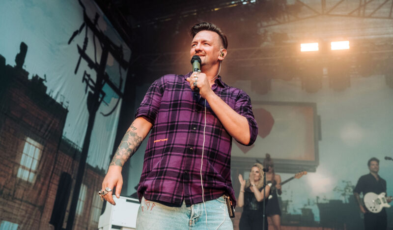 Schlagerpopsänger Ben Zucker in einem karierten Hemd auf der Bühne