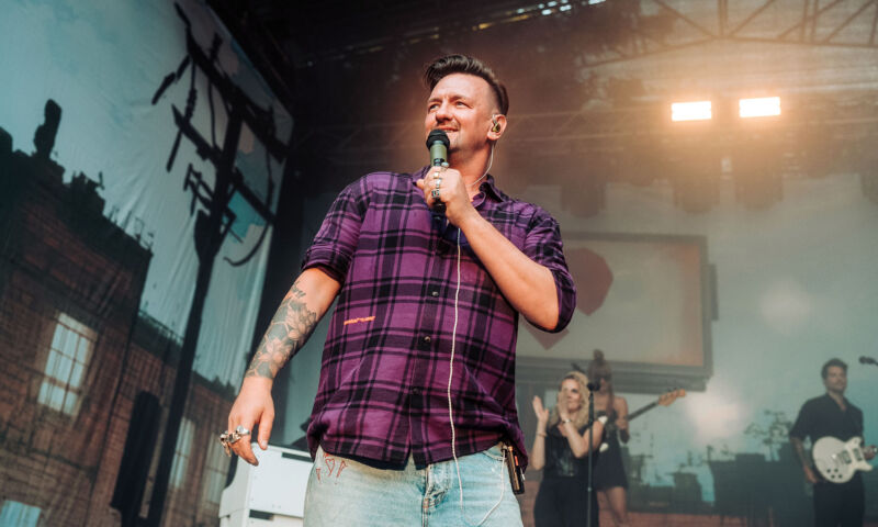 Schlagerpopsänger Ben Zucker in einem karierten Hemd auf der Bühne