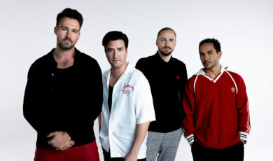 Die Mitglieder der Band Big Time Rush stehen vor einem weißen Hintergrund