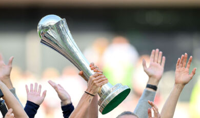 Spielerinnenhände halten den DFB-Pokal der Frauen in die Höhe.