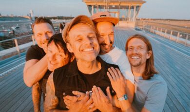 Die Musiker der Band Donots stehen lachend auf einem Schiffsdeck