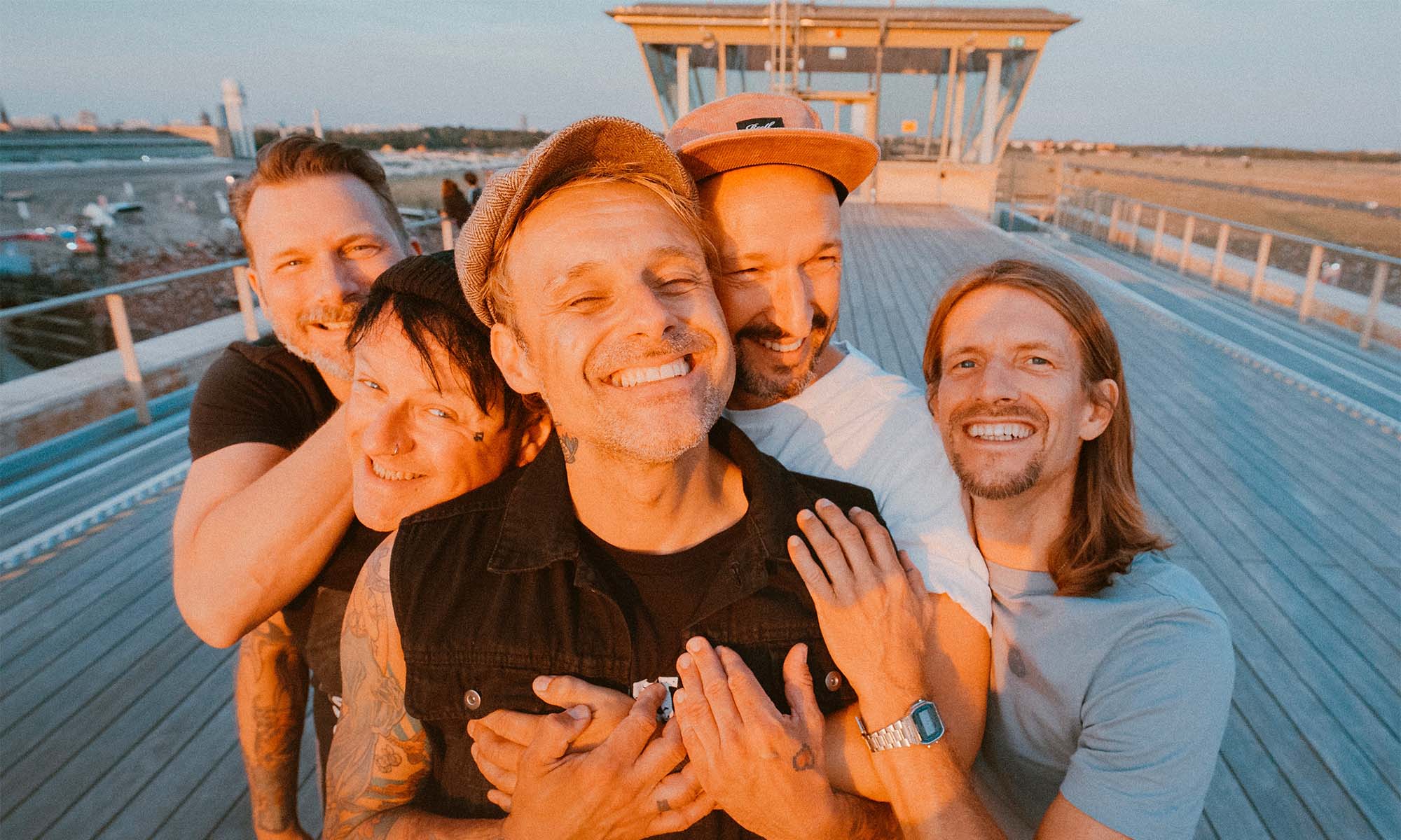 Die Musiker der Band Donots stehen lachend auf einem Schiffsdeck