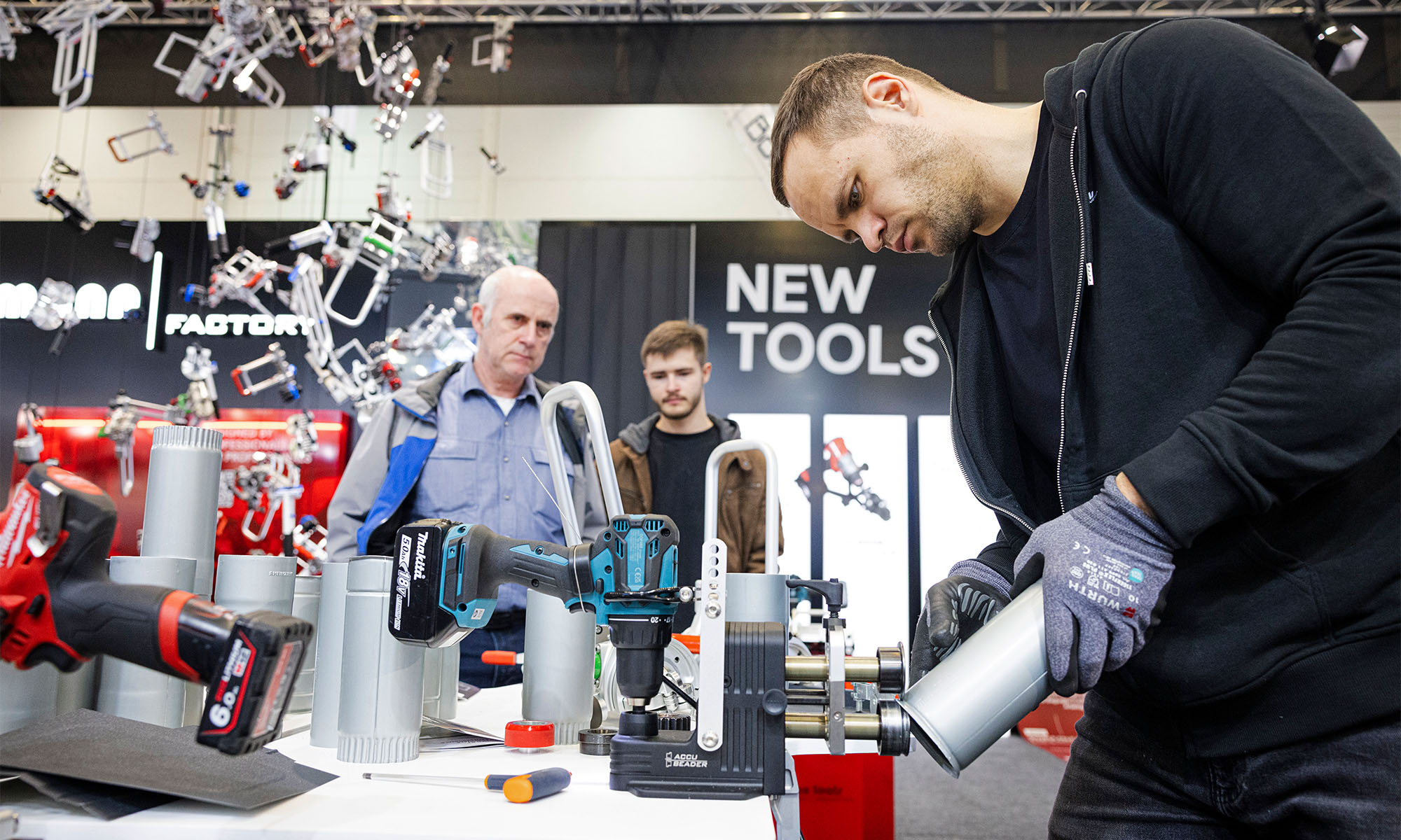 Ein Aussteller präsentiert auf der Messe DACH + HOLZ die Verwendung von Werkzeug