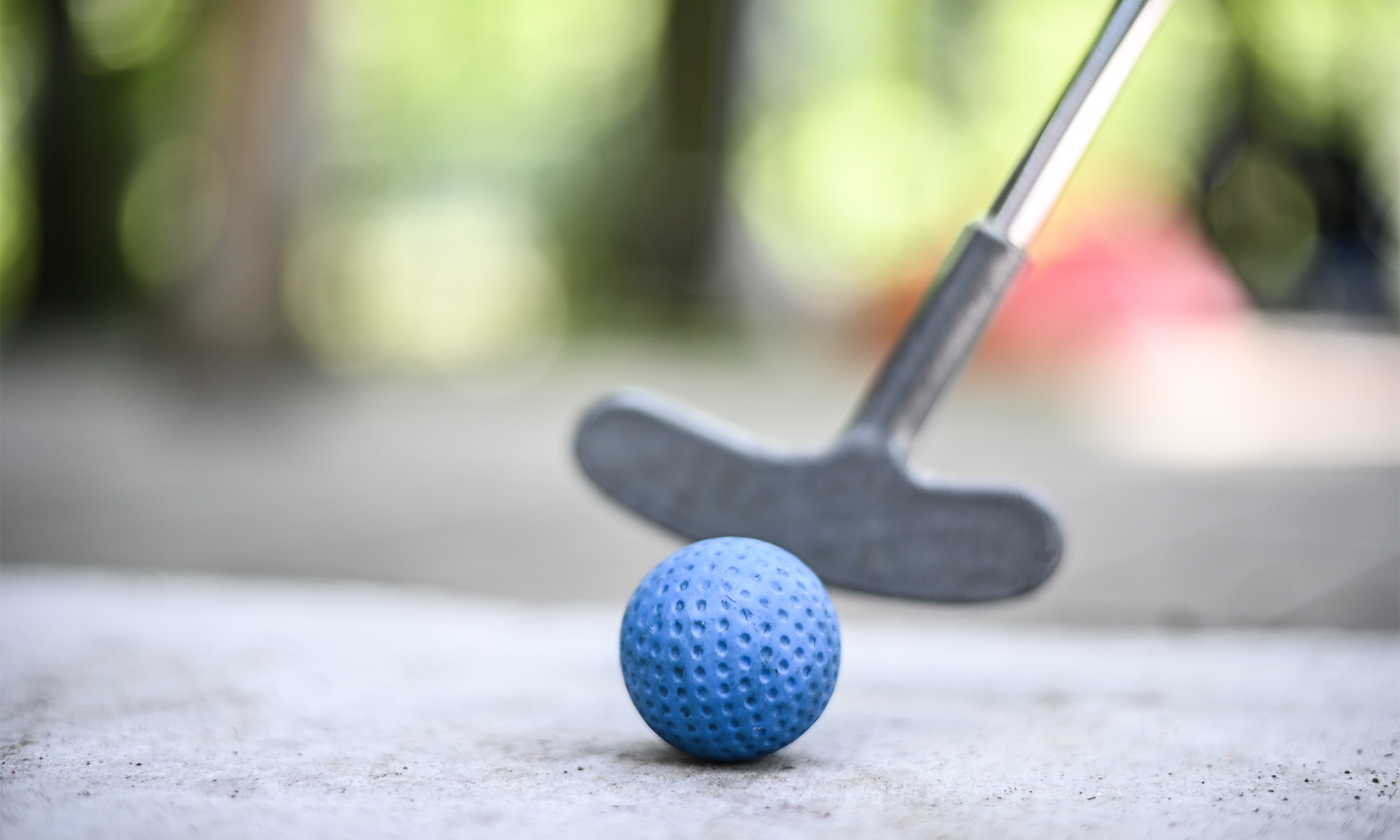 Ein Minigolfschläger und ein blauer Ball