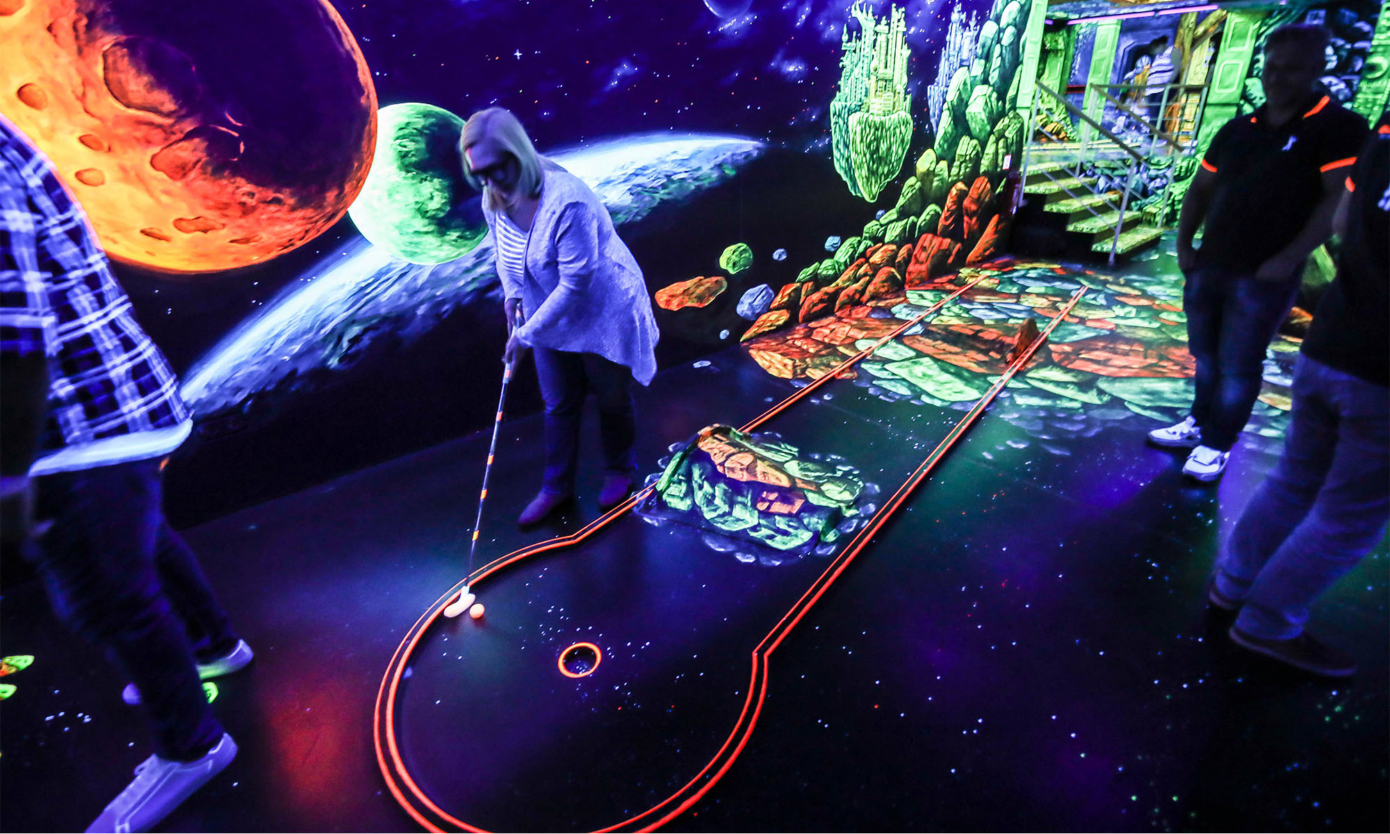 Spieler auf eine Minigolfbahn, die mit Schwarzlicht beleuchtet ist