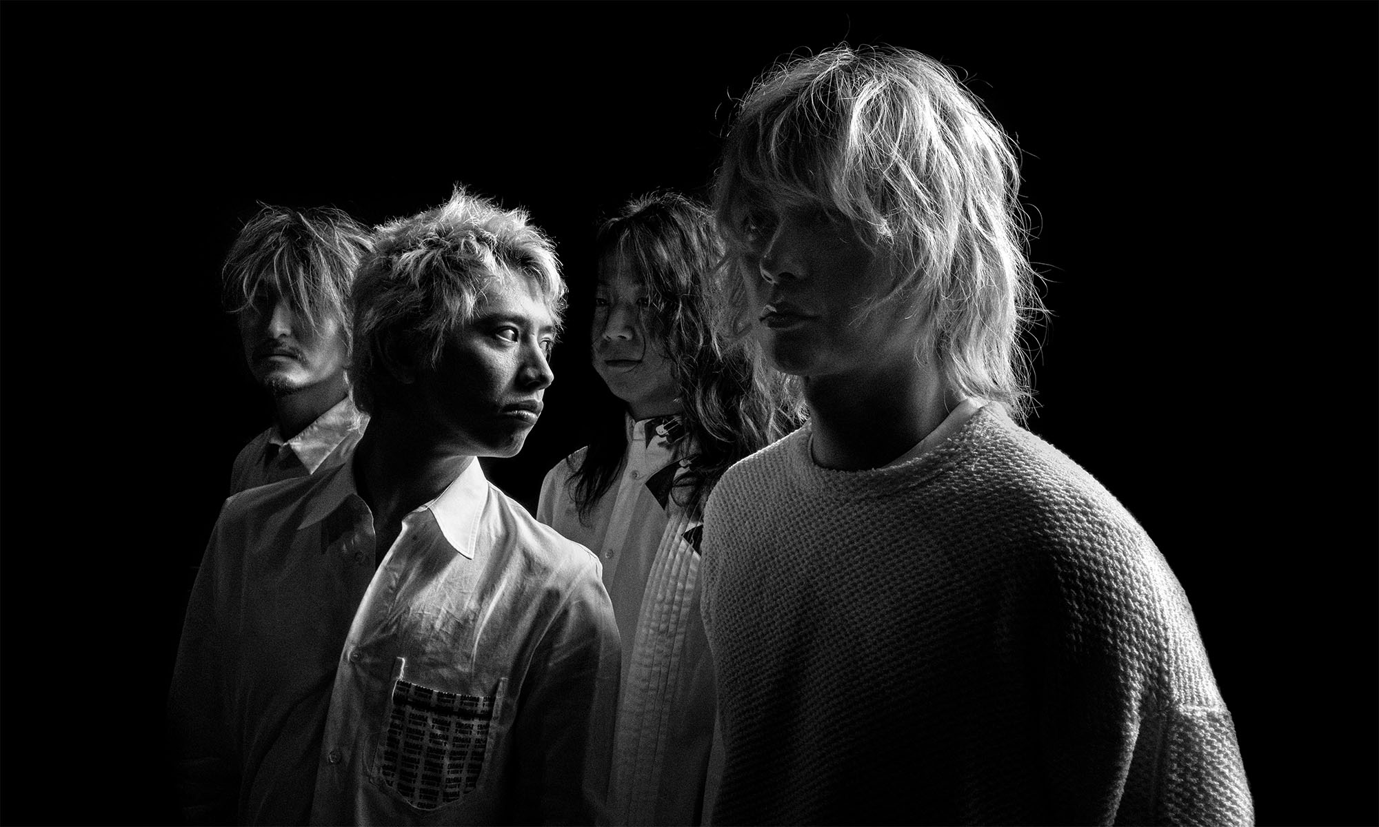 Die Musiker der japanischen Band One OK Rock im Halbdunkel.
