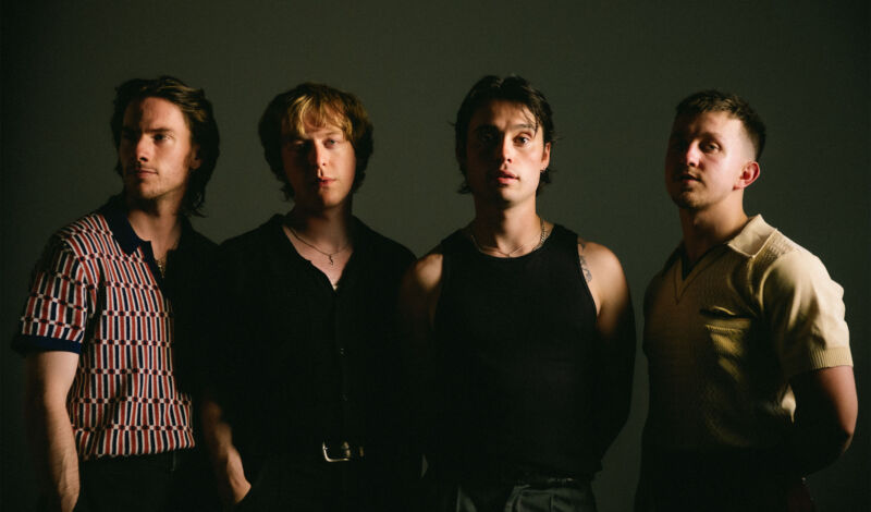 Die Musiker der britischen Band Balancing Act vor einem dunklen Hintergrund