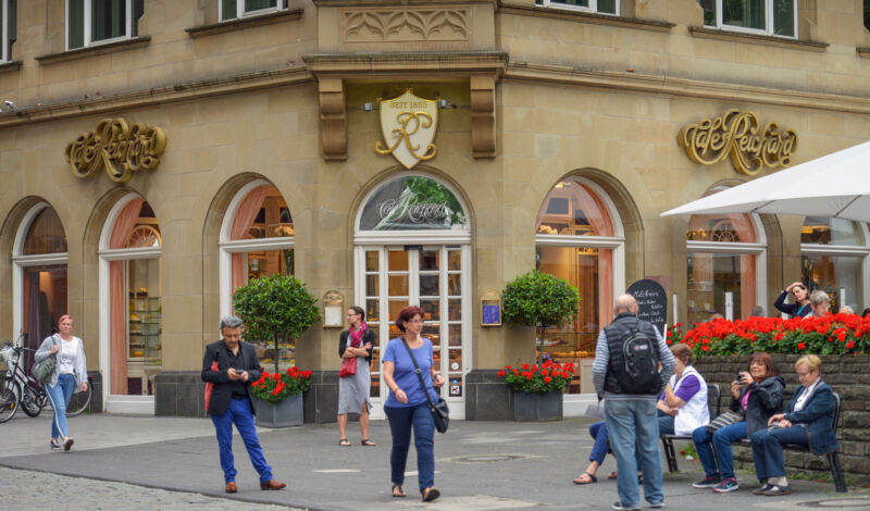 Passanten gehen vor dem Eingang des Cafés Reichard vorbei.