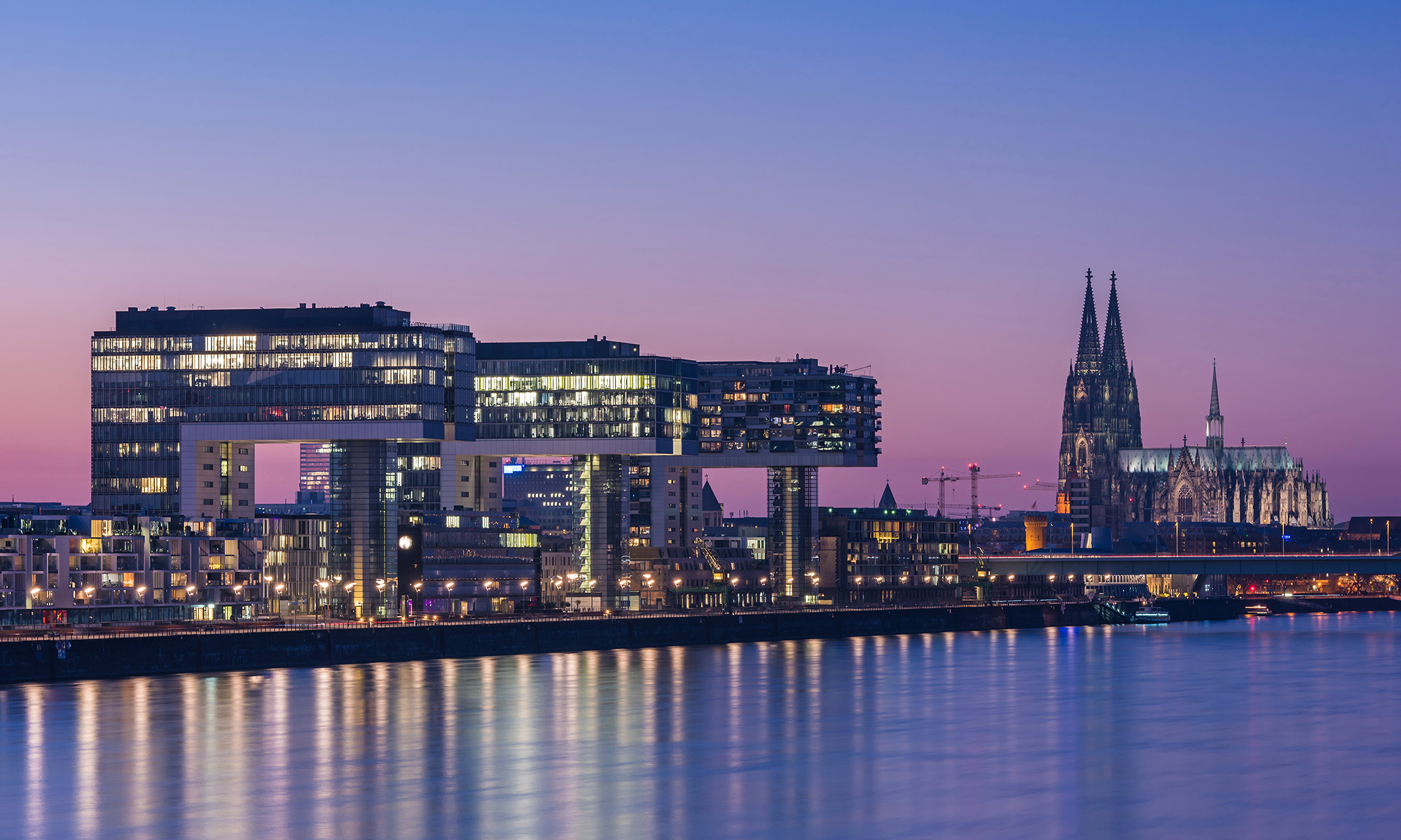 Kölner Rheinpanorama in der Abenddämmerung, mit den Kranhäusern im Rheinauhafen und dem Kölner Dom im Hintergrund