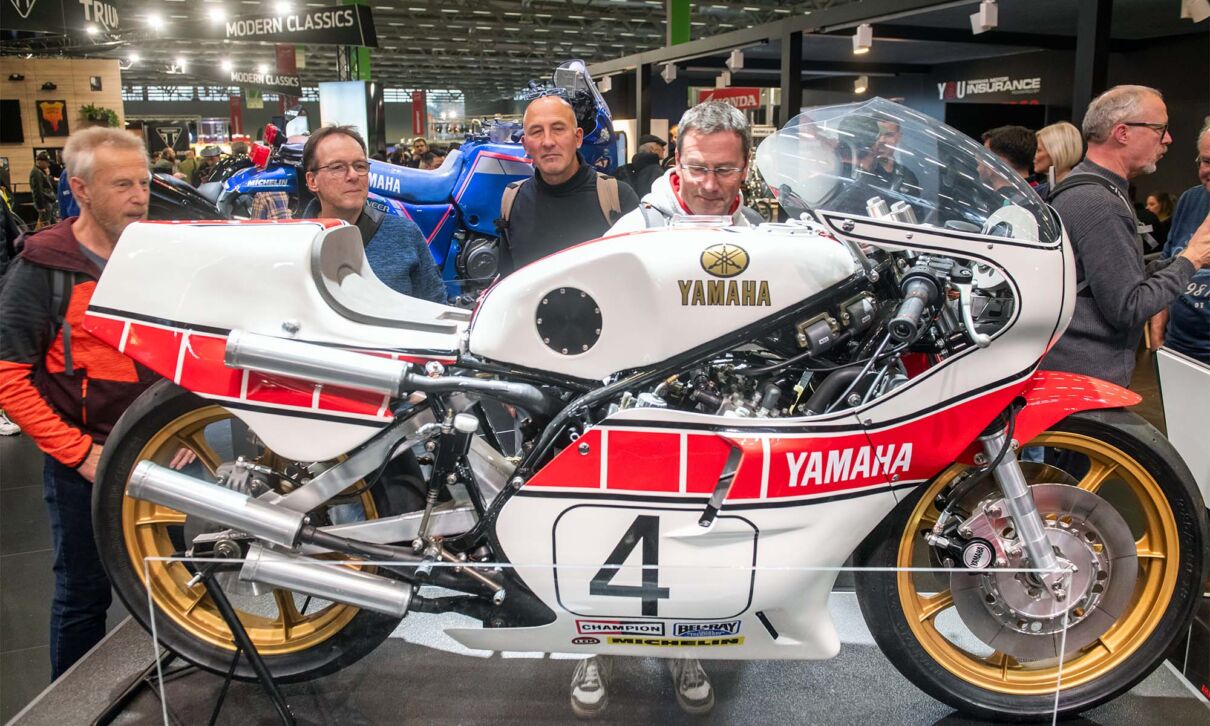 Besucher der Motorradmesse Intermot stehen vor einer Yamaha-Rennmaschine