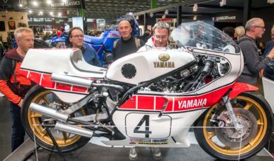 Besucher der Motorradmesse Intermot stehen vor einer Yamaha-Rennmaschine