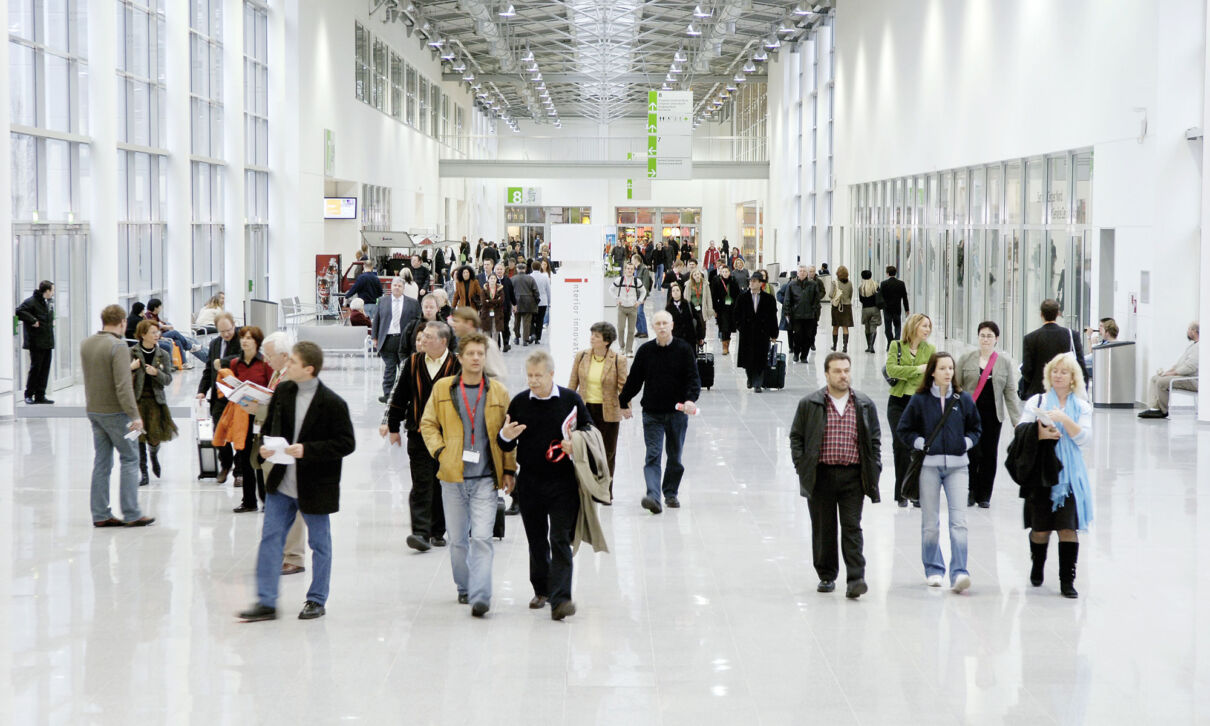 Menschen gehen durch den Messeboulevard der Koelnmesse