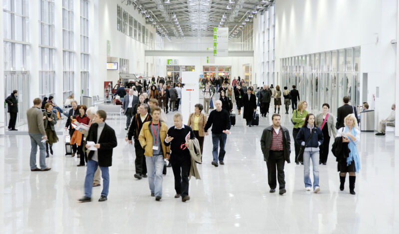 Menschen gehen durch den Messeboulevard der Koelnmesse